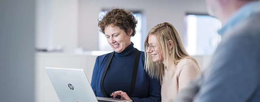 Focus on two people looking at laptop-screen