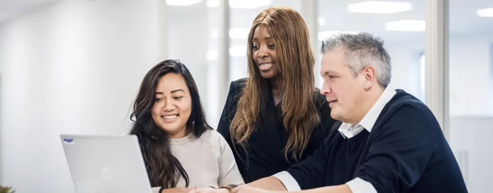 close up of three people at a table with laptop