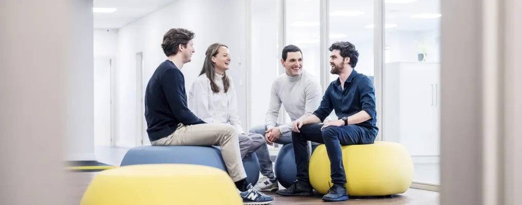 four people sitting on cosy seats in a meeting