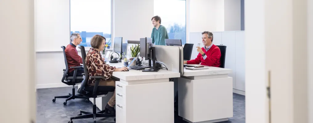 Office room with four people working at desk