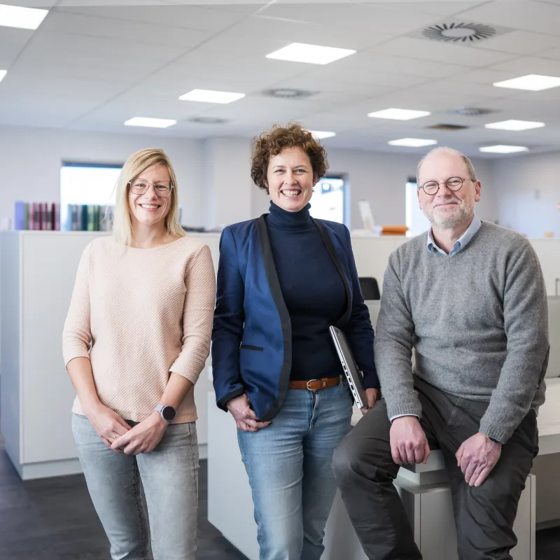 three people posing in office