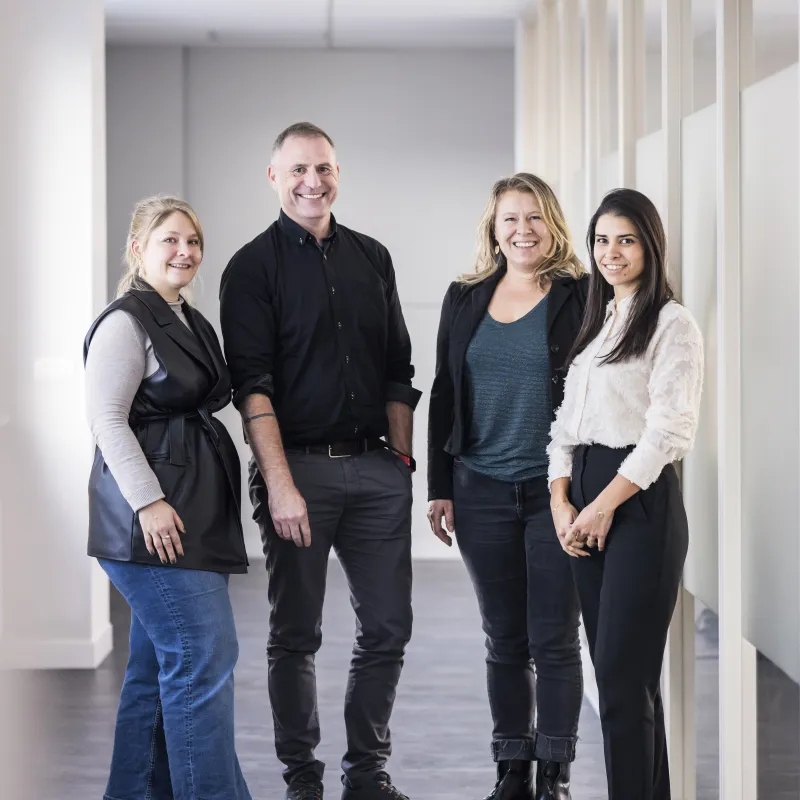 Four people posing in a corridor