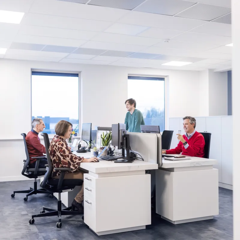 Office room with four people working at desk