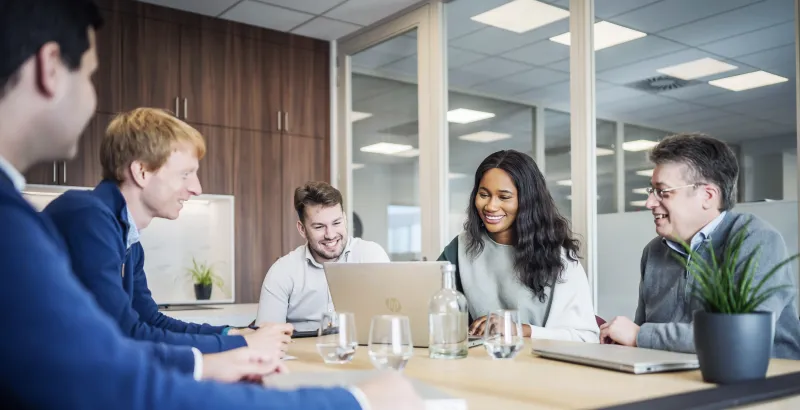 five people at the table in a meeting room