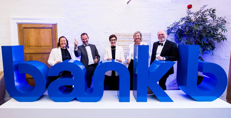 Het directiecomité poseert trots bij het nieuwe logo van BankB